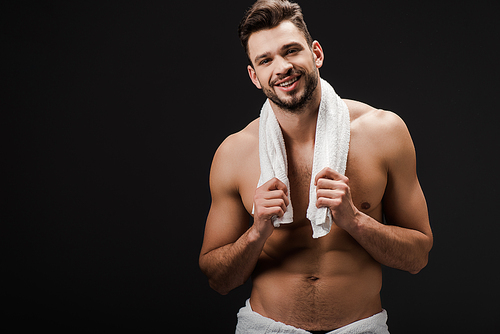 handsome brunette man with towel isolated on black