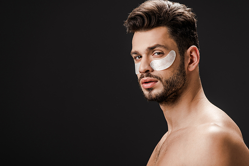 handsome sexy nude man with eye patches on face isolated on black