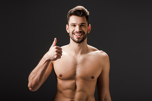 cheerful sexy naked man showing thumb up isolated on black