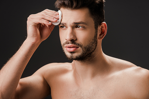 sexy naked man using cosmetic cotton pad isolated on grey