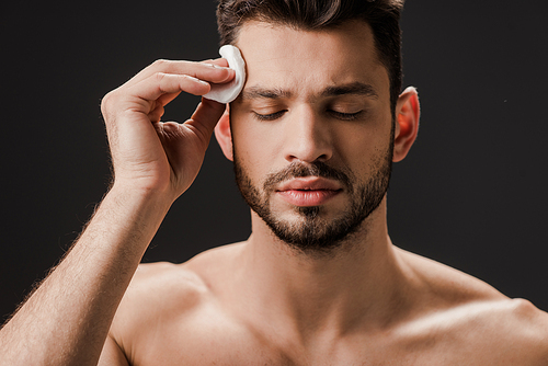 brunette sexy naked man using cosmetic cotton pad isolated on grey