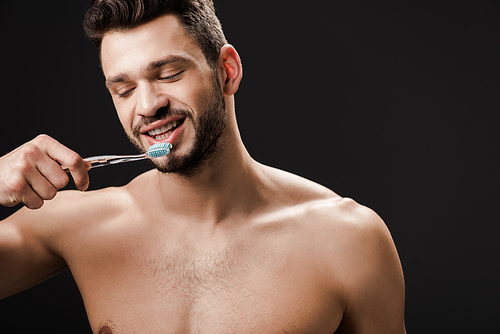 positive nude man with tooth brush isolated on black