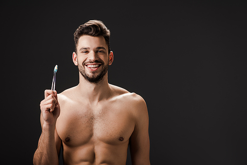 sexy smiling nude man with tooth brush isolated on black