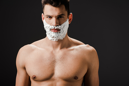 sexy naked man with shaving foam on face isolated on black