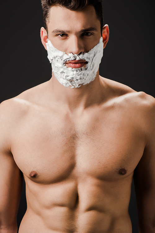 sexy naked man with shaving foam on face isolated on black