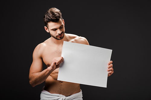 sexy shirtless man in towel holding blank placard isolated on black
