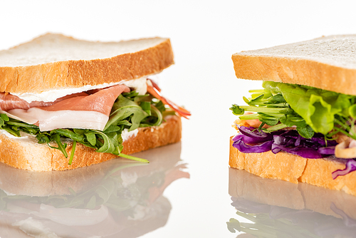 fresh green sandwiches with prosciutto on white surface