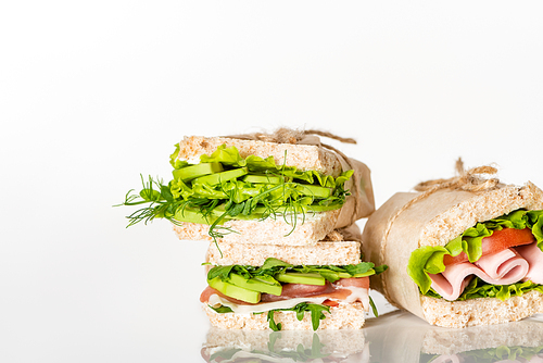 fresh green sandwiches with avocado and meat on white surface