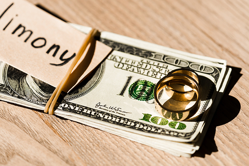selective focus of paper with lettering on dollar banknotes near engagement rings