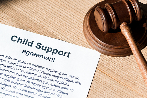 wooden gavel near document with child support agreement