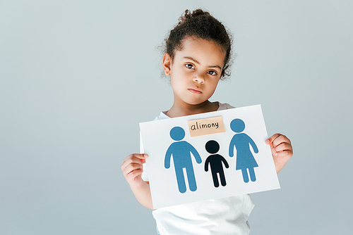 frustrated african american kid holding paper with drawn family and alimony lettering isolated on white