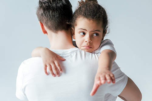 back view of foster father taking away sad african american daughter isolated on white, custody concept