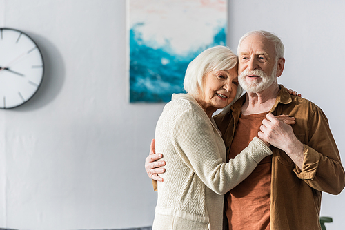 cheerful smiling couple smiling while dancing at home