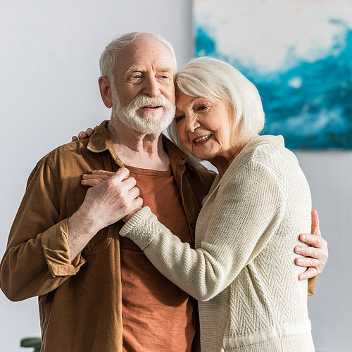 happy senior couple smiling while dancing at home