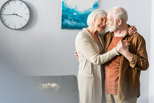 selective focus of happy senior couple dancing at home