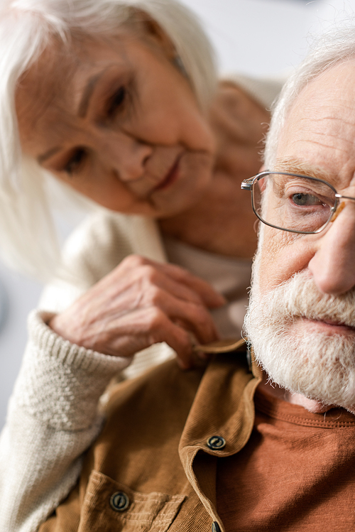 selective focus of senior woman looking at husband with dementia disease