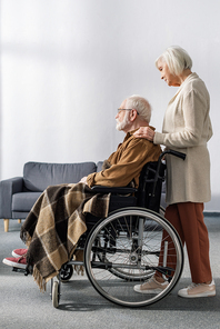 side view of senior woman touching shoulder of . husband, sick on dementia