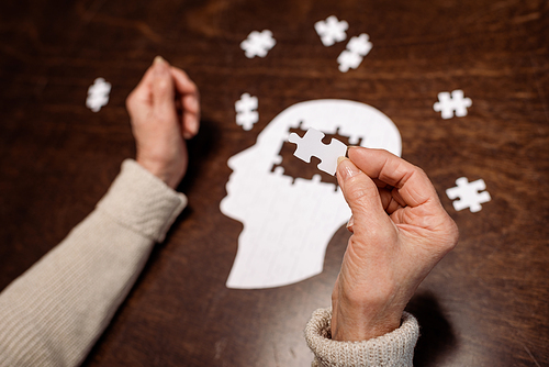 cropped view of woman colleting jigsaw puzzle as dementia therapy