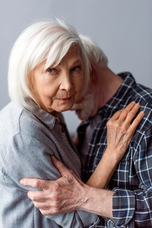 upset senior woman  while hugging husband suffering from dementia