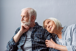 dreamy senior woman leaning on shoulder of thoughtful husband looking away