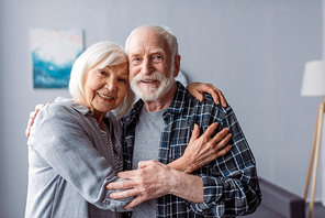 happy senior couple smiling and embracing while 