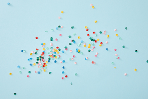 top view of colorful confetti scattered on blue background