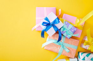 top view of festive colorful gift boxes on yellow background