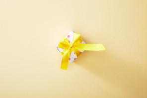 top view of festive colorful gift box on beige background