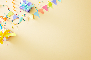 top view of festive colorful confetti and gift boxes on beige background