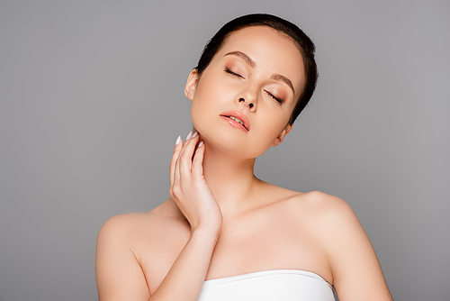 beautiful woman with closed eyes touching skin isolated on grey