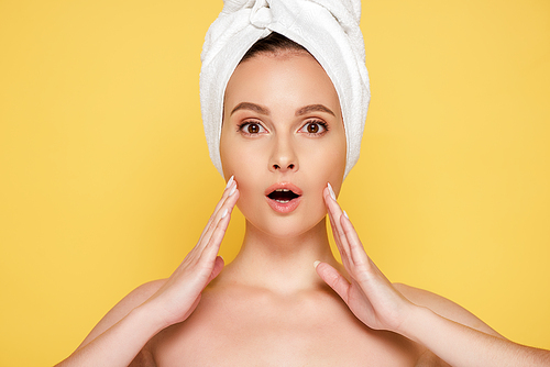 shocked beautiful naked woman with towel on head isolated on yellow