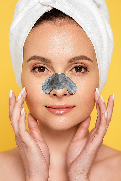 beautiful naked woman with towel on head and blackhead remover on  nose isolated on yellow