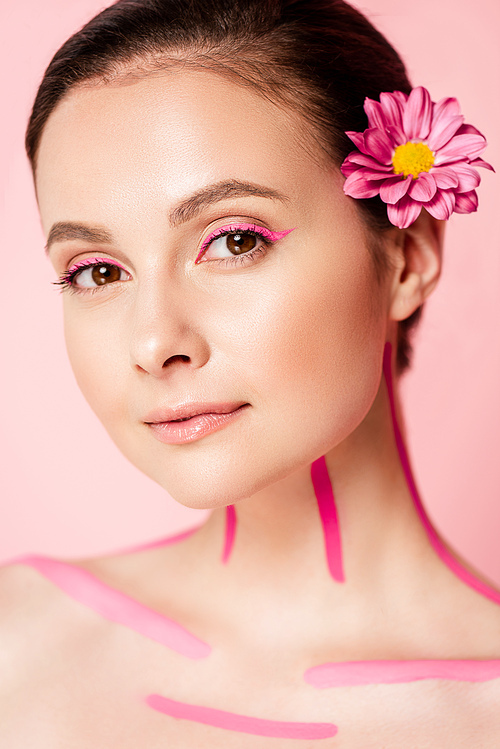 naked beautiful woman with pink lines on body and flower in hair isolated on pink