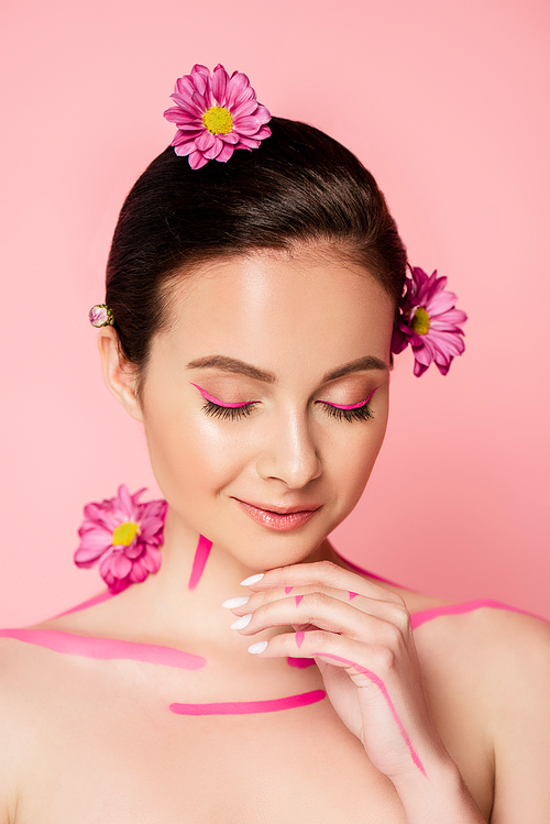 naked beautiful woman with closed eyes, pink lines on body and flowers in hair isolated on pink
