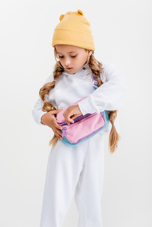 blonde girl in sportswear unfastening belt bag isolated on white