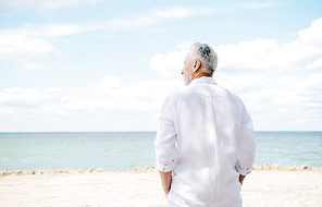 back view of senior man in white shirt at beach in sunny day