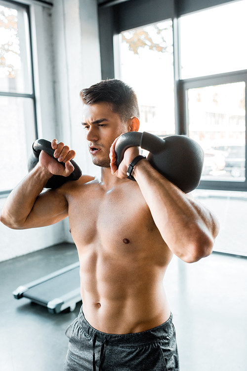 handsome sportsman working out with weights in sports center