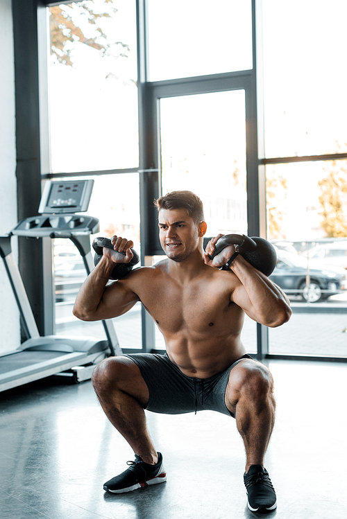 handsome sportsman working out with weights in sports center