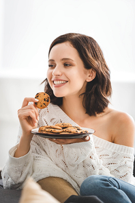 beautiful happy woman eating cookies at home