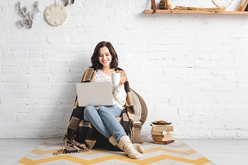 beautiful happy woman with cookies and coffee using laptop