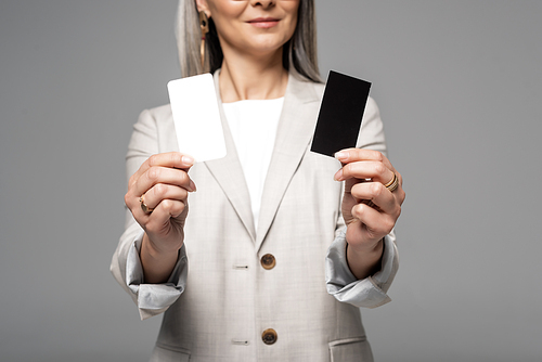 cropped view of businesswoman holding business cards isolated on grey