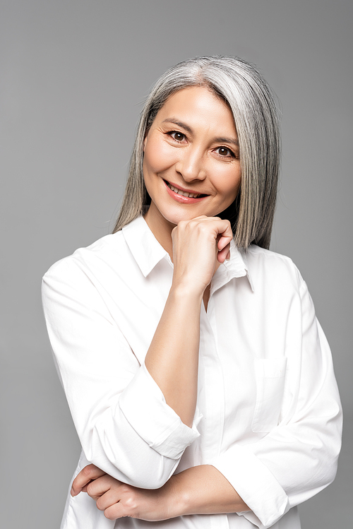 smiling asian woman with grey hair isolated on grey