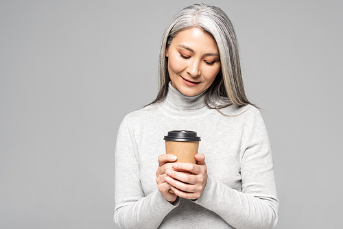 attractive asian woman in turtleneck with grey hair holding coffee to go isolated on grey