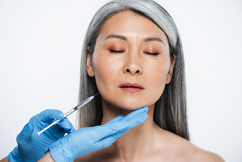 attractive naked asian woman and doctor in latex gloves holding syringe with beauty injection isolated on grey