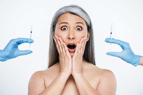 shocked nude asian woman and doctors in latex gloves holding syringes with beauty injections isolated on grey
