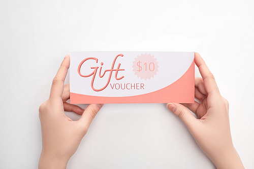 Top view of woman holding gift voucher with 10 dollars sign on white background
