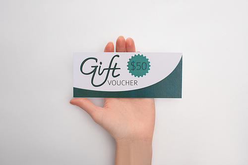 Cropped view of woman holding gift voucher with 50 dollars sign on white background