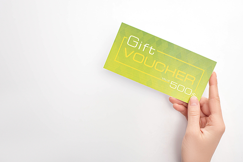 Top view of woman holding green gift voucher on white background