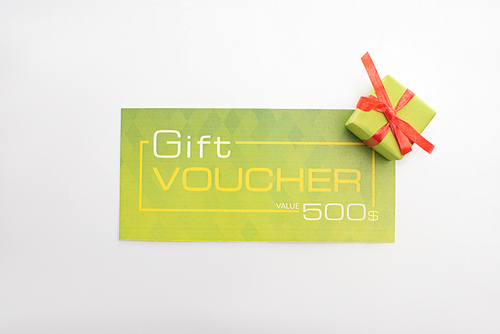 Top view of green gift voucher with gift box isolated on white