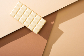top view of delicious whole white chocolate bar on beige background